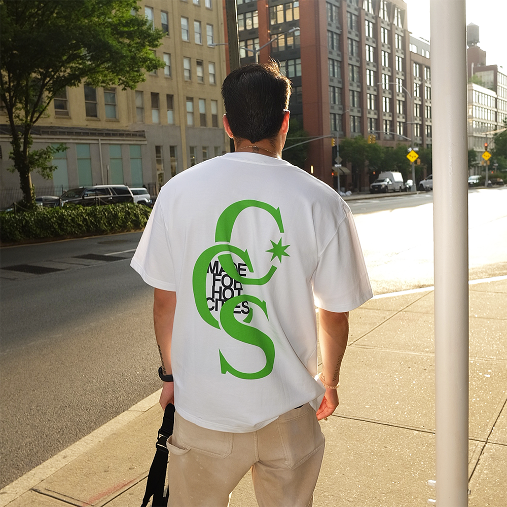 Modelo de espaldas llevando la camiseta verde «CCS Hot City» de Caracas Merch